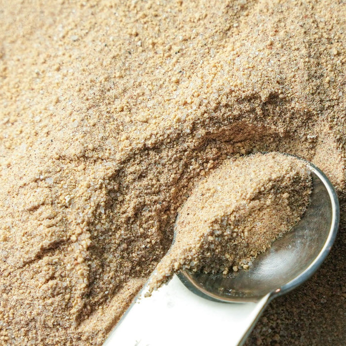 Spoon filled with brown powder on a bed of brown powder