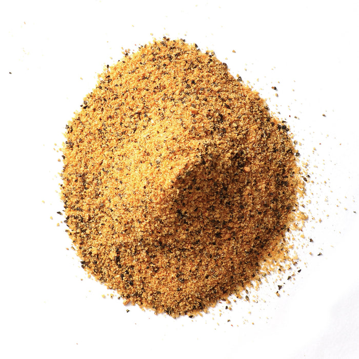Closeup of yellow-tan granules with orange and black flecks mixed in