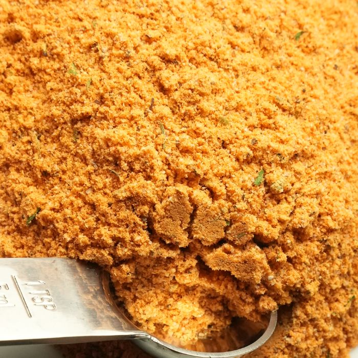 Close-up of a spoonful of orange spice mix