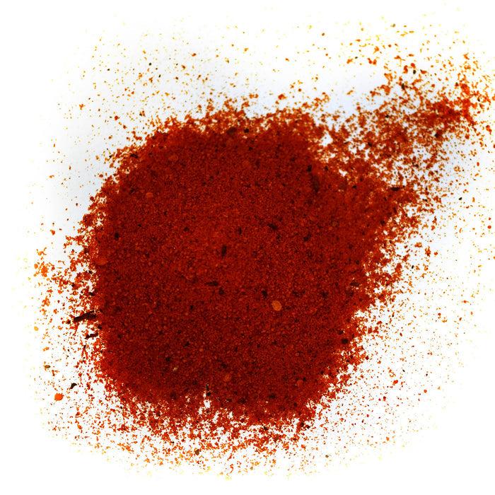 Closeup of bright red granules with orange seeds and dark red flecks mixed in