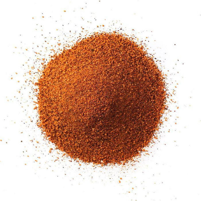 Closeup of reddish-orange fine granules with black flecks mixed in