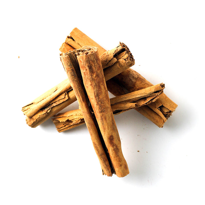Closeup of dried, light tan, rolled strips of Cinnamon bark