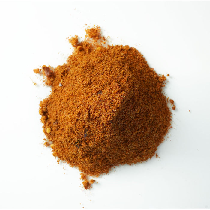 Closeup of orange small granules with red flakes and seeds