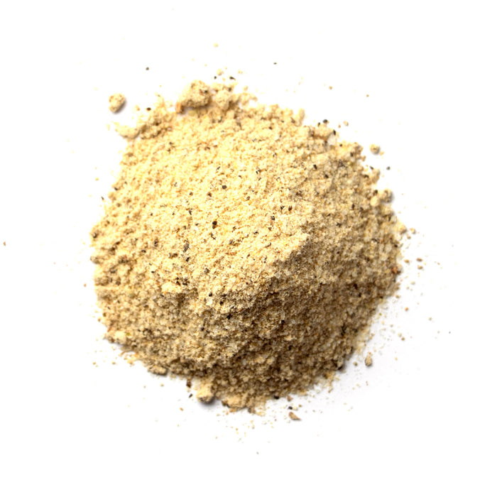 Closeup of off-white powder with dark green flecks mixed in
