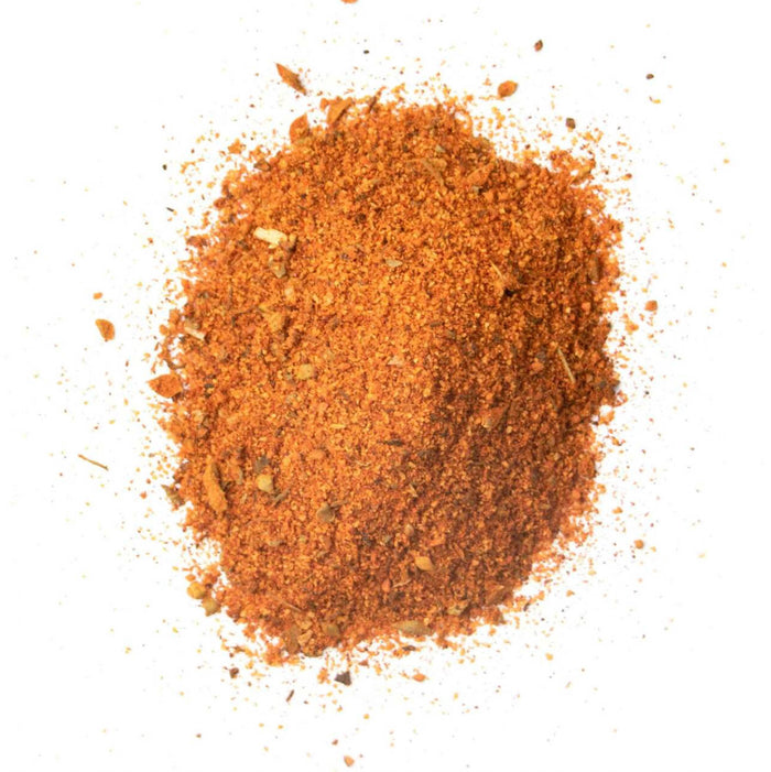 Closeup of bright orange granules with yellow and green flakes mixed in