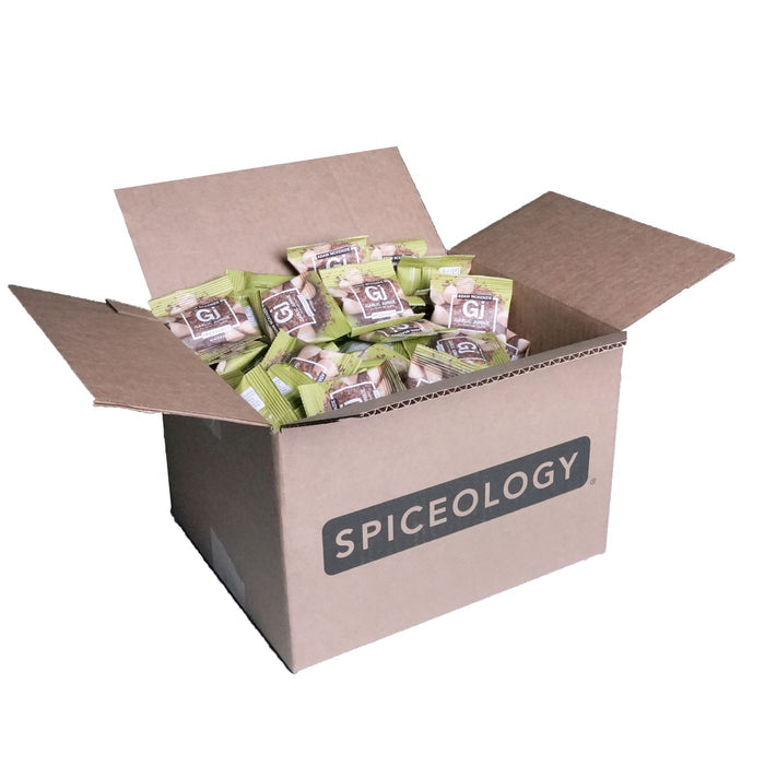 Cardboard box labeled 'Spiceology' filled with Garlic Junkie packets on a white background