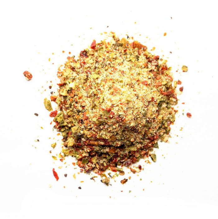 Closeup of of pale yellow granules with green and red flakes mixed in