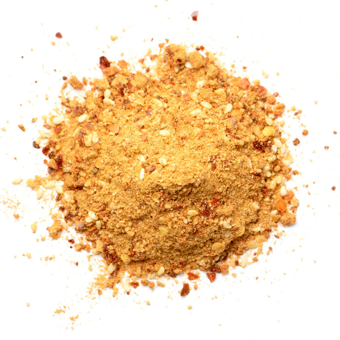 Closeup of light orange powder with white and red flakes mixed in