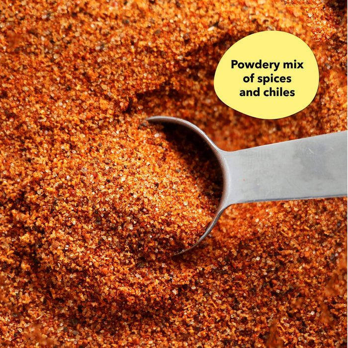 Overhead close-up of a reddish-orange spice blend with a silver measuring spoon; a callout reads Powdery mix of spices and chiles