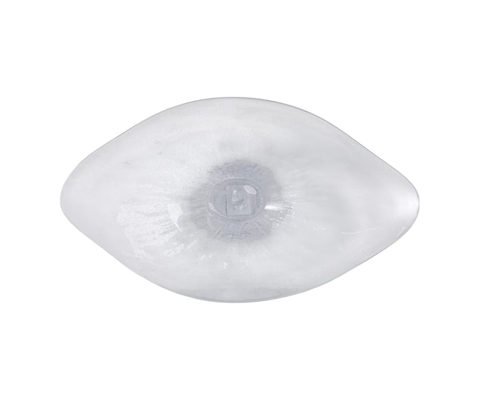 A clear, oval-shaped silicone breast implant is shown on a white background, viewed from above. The center appears slightly indented, highlighting the implant’s smooth and transparent surface, reminiscent of the Petal Frost Bowl with its subtle curves and clarity.