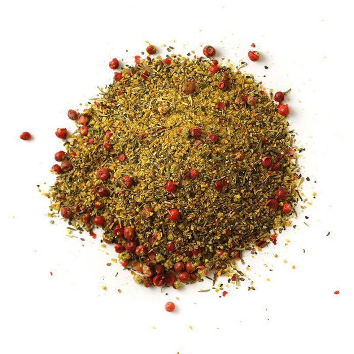 Closeup of dark yellow granules with green flakes and pink peppercorns mixed in