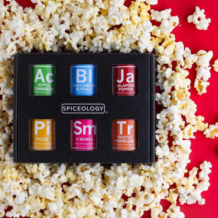 Spiceology popcorn seasoning gift set with popcorn on a red background