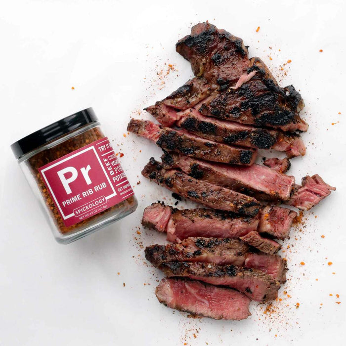 Jar of Spiceology Prime Rib Rub next to a sliced steak on a white background
