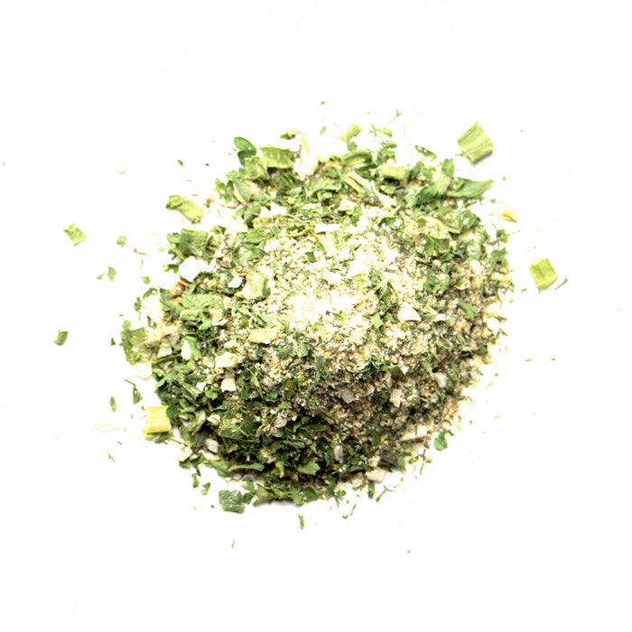 Closeup of off white powder with green herb flakes
