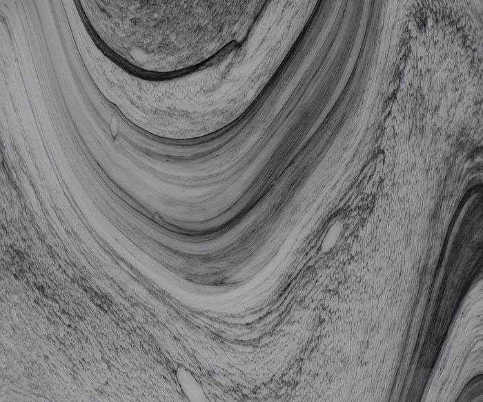 Certainly! Here is the revised sentence using the product data: A black and white abstract image featuring swirling, curved lines and textured patterns reminiscent of natural stone or a hand-finished glass surface, echoing the intricate detailing found on the Retro Swirl Vase.
