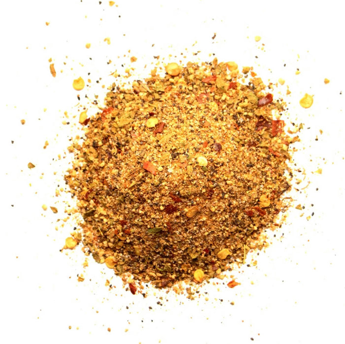 Closeup of orange granules with ted pepper flakes and yellow seeds