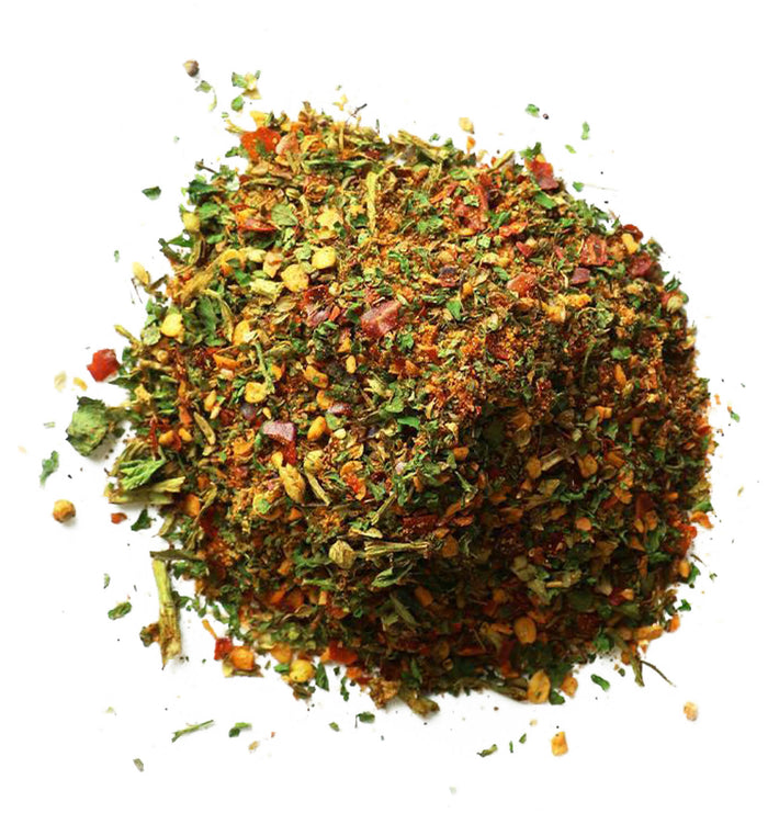 Closeup of orange granules mixed with green flakes and red pepper flakes