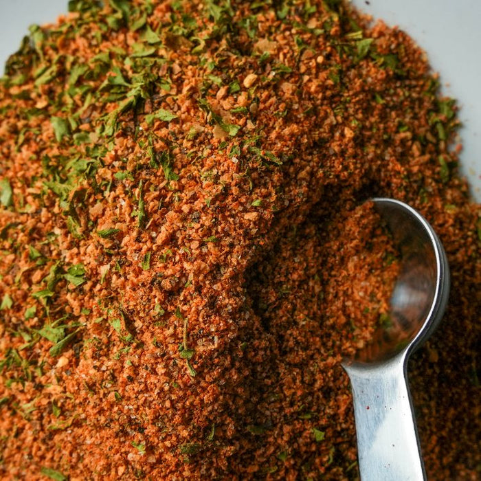 Close-up of a spice blend with a spoon on a gray background