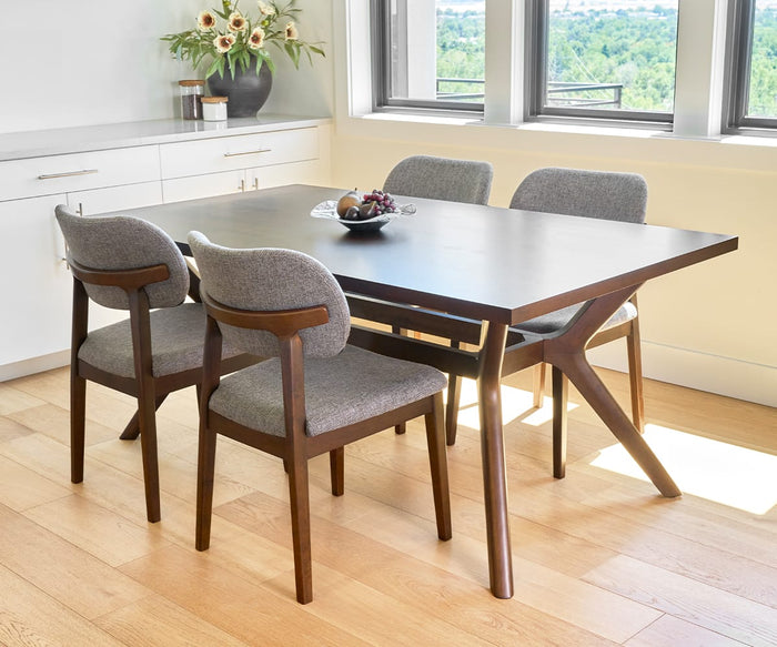 A modern dining area with a dark wood table, four Severin Dining Chairs in dark gray, a bowl of fruit, light wood flooring, white cabinets, a vase of flowers, and large windows showcasing greenery outside.