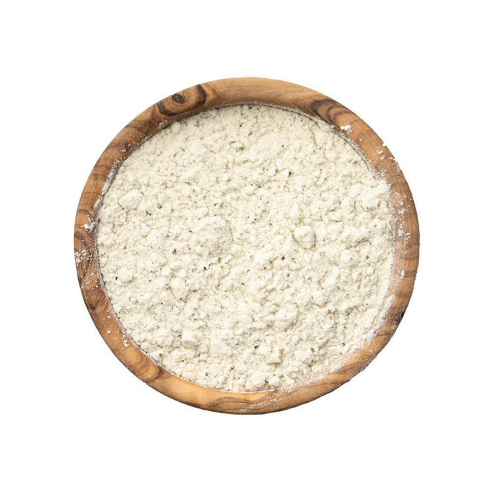 Closeup of an off-white powder with flecks of tiny green bits