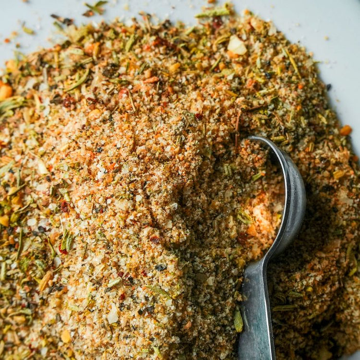 Spice blend with a spoon on a white background