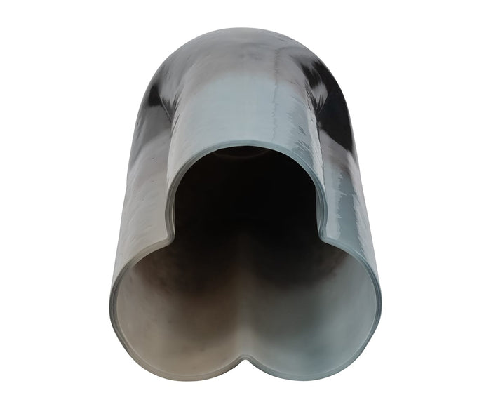A close-up view of the Twilight Vase showcases its shiny, gray, hollow metal form with a clover-shaped cross-section reminiscent of the elegant lines found in contemporary vases, photographed against a white background.